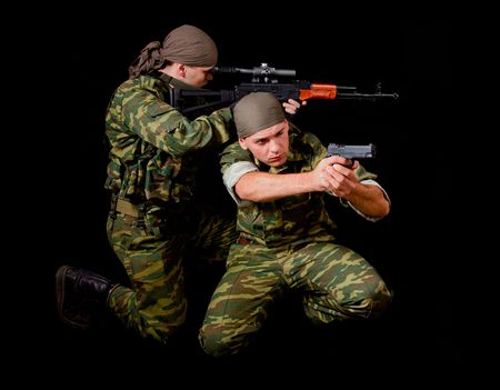 Two soldiers in camouflage uniform with weapon, isolated on black background の写真素材