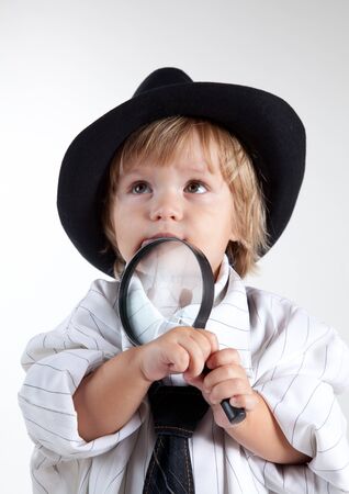 Young detective with magnifying glass, studio shot の写真素材