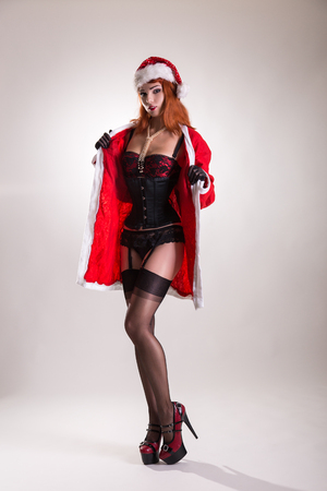 Pinup girl in Santa Claus suit and beautiful lingerie, Christmas and New Year theme の写真素材