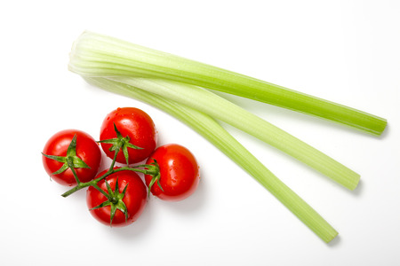 Top view of bunch of fresh tomatoes and celery sticks on white background の写真素材