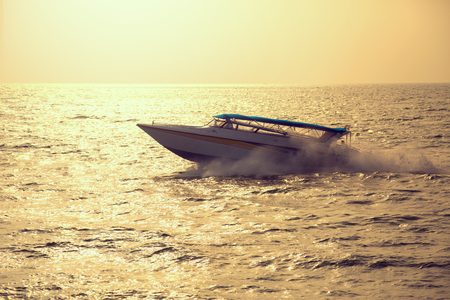 Motor boat on sunset, vintage toned image の写真素材