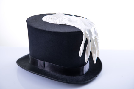 Black wizard top hat with white glove, studio shot on white background with reflection  の写真素材
