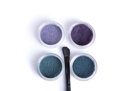 Top view of jars with eye shadows, and makeup brush, isolated on white backgroundの写真素材