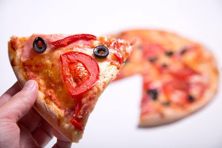 Male hand picking delicious pizza slice, studio shotの写真素材