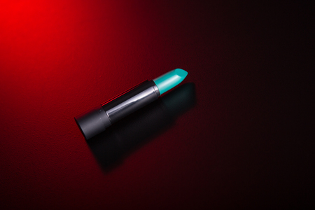 Teal green lipstick on red background, studio shotの写真素材