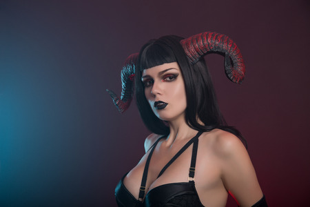 Sexy demon girl with red horns, studio shot for Halloweenの写真素材