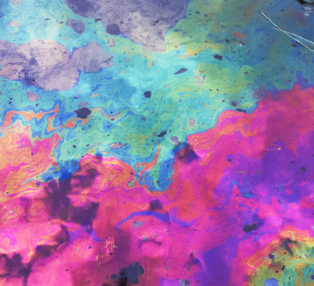 Texture background of oil spilled in rain water generating a colorful effect due to sunlight reflectingの写真素材