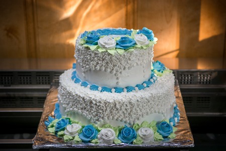 big wedding cake with blue flowers with interesting lighting