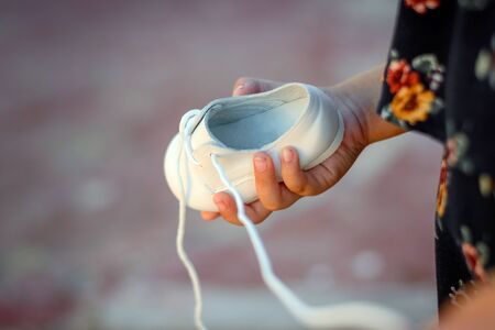 Little white shoe in his mothers arms.の写真素材