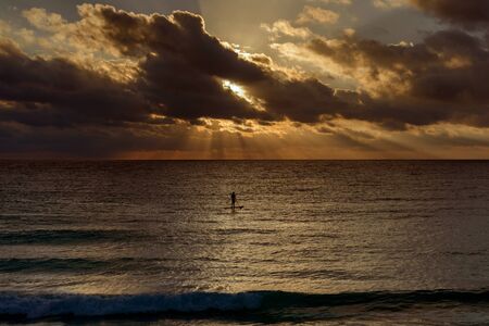 Silhouette of a man on a surf in the sea.の写真素材
