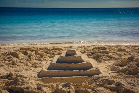 Pyramid of sand on the shores of the sea.の写真素材