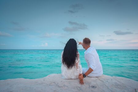 A man and a woman are sitting on the seashore.の写真素材