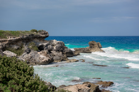 The coastline of the Caribbean Sea with white sand and rocks in Cancun.の写真素材