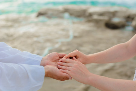 Man and woman, newlyweds holding hands with blurred background.の写真素材