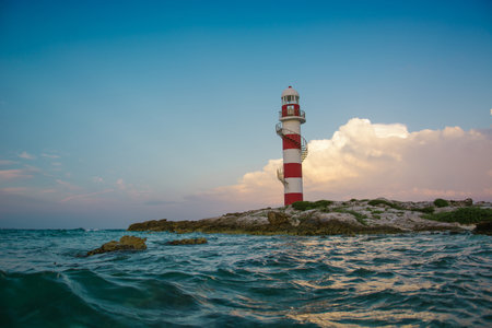 Lighthouse on a rocky shore in Cancun. Clear sky and blue sea. Mexico.