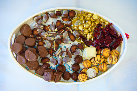 Variety of chocolate cookies and candies on a white table for parties or celebrations. Perfect for festive events, dessert tables, and sweet indulgence.の写真素材