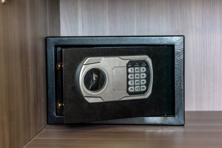 Close up view of electronic safe with keypad installed inside wooden cabinet. Home security and protection concept in modern apartment interior.の写真素材