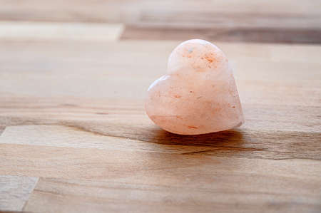 Pink stone heart with rock stones in background. Symbol of love.の写真素材
