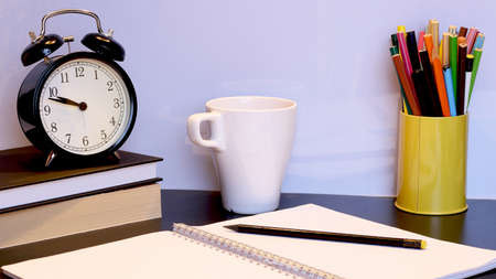 Back to school background with alarm clock, books, glasses, orange and pencilsの写真素材