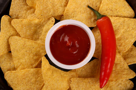 Mexican nachos in Wooden Bowl tortilla chips with chilli sauce, salsa and cheese dip, Black...