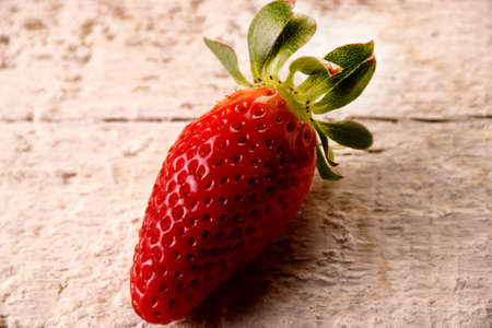 One strawberry fruits on white wood table background, selective focusの写真素材