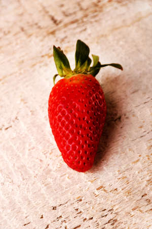 One strawberry fruits on white wood table background, selective focusの写真素材
