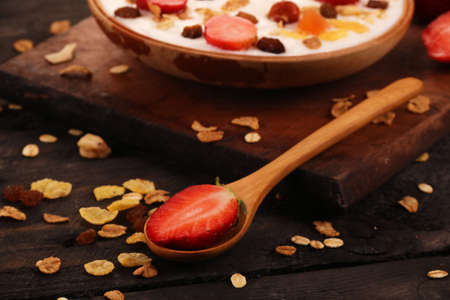 Bowl of yogurt with strawberries and granola muesli, over a white wood background.の写真素材