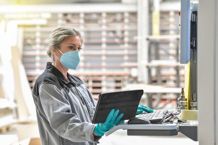 Woman engineer operating on a industrial digital machineの写真素材