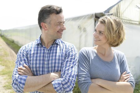 Young farming couple in front of  the greenhouseの写真素材