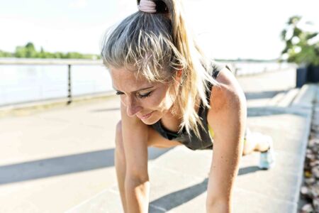young woman doing her stretching after her joggingの写真素材