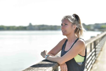 Female runner during her running session along a river in the cityの写真素材