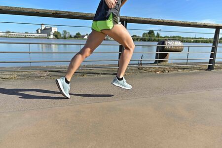 view of woman legs during a running cession along the river