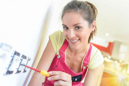 Female technician is screwing an electric socket