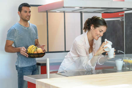 Happy young couple is ready to have breakfast at homeの写真素材
