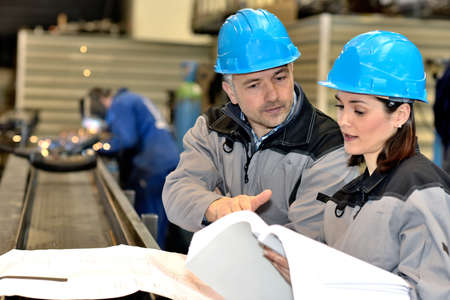 A couple of metal factory workers are trying to solve an issueの写真素材