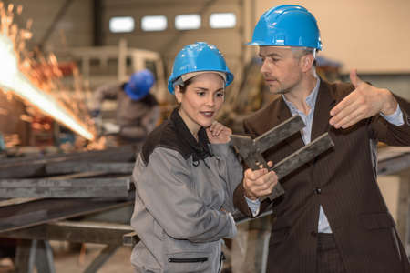 Male manager is showing his female worker a problem with the sizeの写真素材