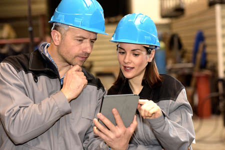 Positive woman is showing his manager a solution for a factory issueの写真素材