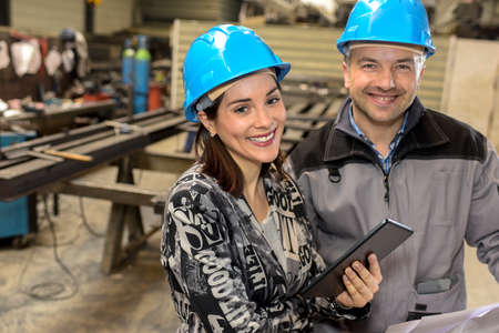 Portrait of happy female manager and male worker smiling at the cameraの写真素材