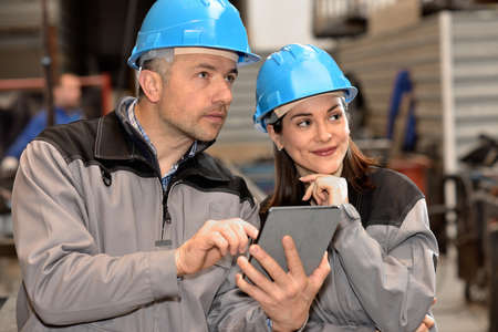 Happy factory workers are looking at something in the factoryの写真素材