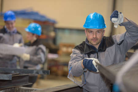 Male worker showing thumb down in factoryの写真素材