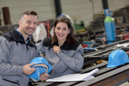 Portrait of happy female and male workers smiling at the cameraの写真素材