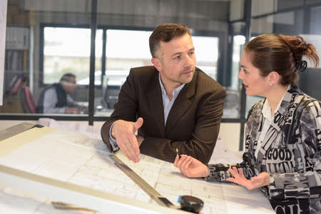 Female talking to her boss about her architectural ideaの写真素材