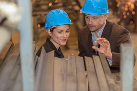 Male supervisor tries to explaing something to female colleague in the factoryの写真素材