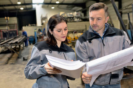 Female worker showing paperwork to male supervisor in the factoryの写真素材