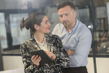Female architect is proudly showing his boss her new tabletの写真素材
