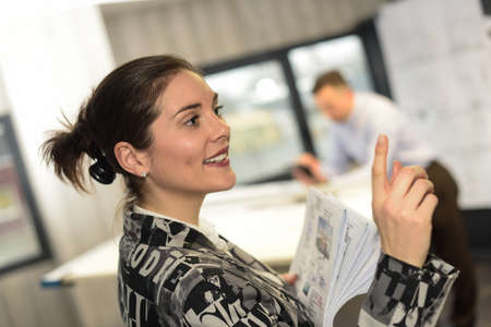 Positive female worker is talking to her colleaguesの写真素材