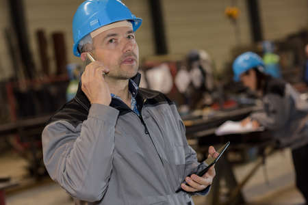 Concentrated male factory worker on the phoneの写真素材