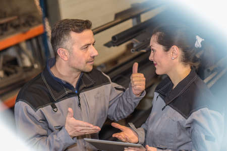 Male colleague is happy with his female coworker, he shows her a thumb-upの写真素材