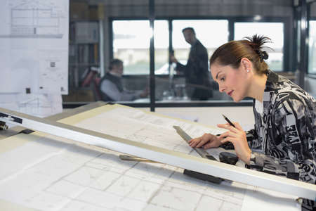Hardworking young female apprentice is drawing with a rulerの写真素材