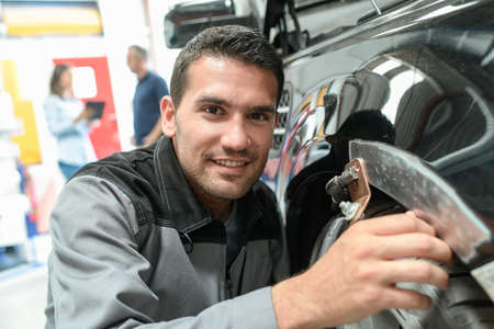 Car body worker repairs domage on a carの写真素材